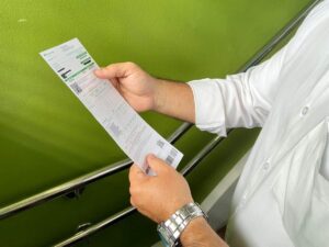 Pessoa segura uma conta de energia elétrica em mãos.